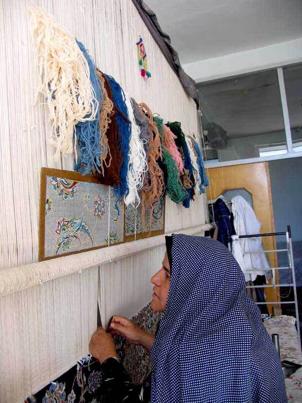 Knotting the pile of a hand-knotted rug.